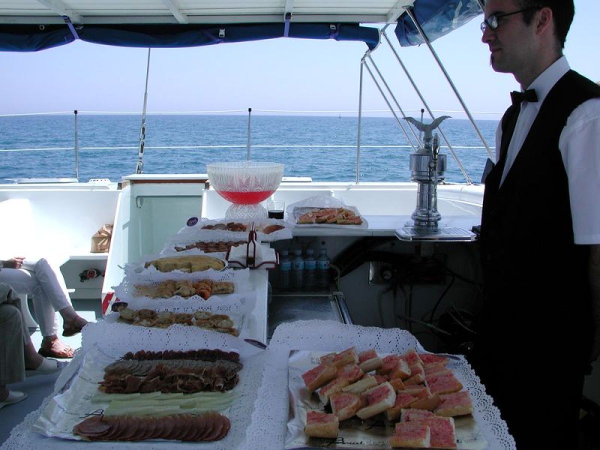 Camarero sirviendo catering a bordo del catamarán