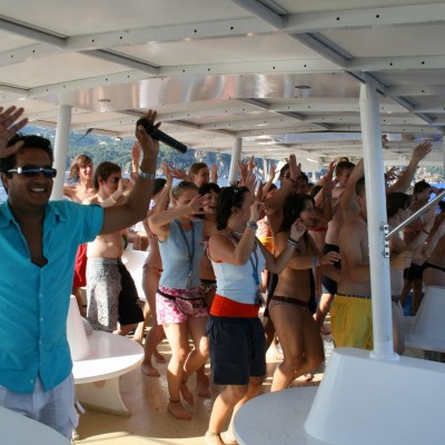 Gente cantando y bailando a bordo del catamarán