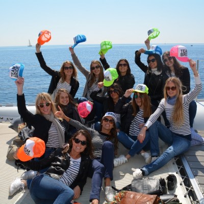 Grupo de chicas enseñando gorras de colores