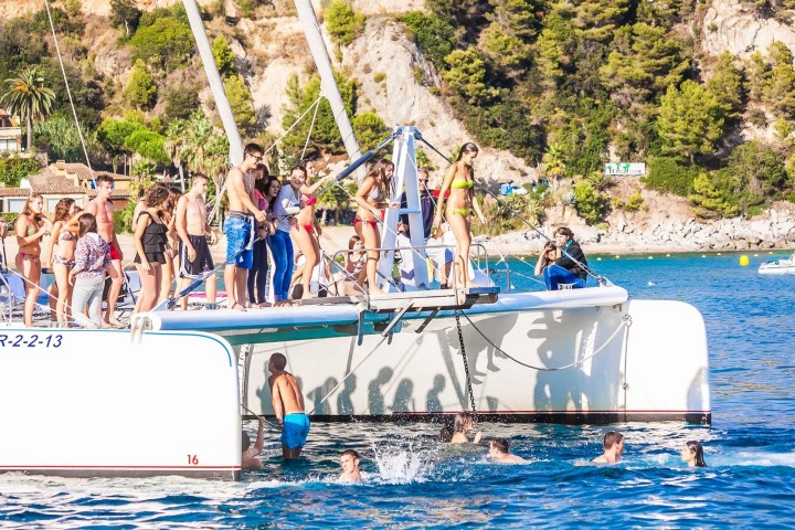 Grupo saltando del trampolín del catamarán